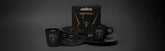 A Lavazza espresso gift set featuring two black Lamborghini-branded cups, matching saucers, a black geometric-patterned plate, and a Lavazza espresso box, all arranged on a dark background.